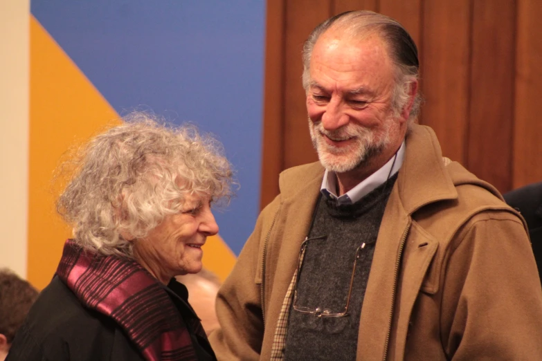 a man and woman smile at each other as they stand next to each other