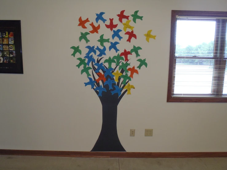 paper birds in a tree on a wall