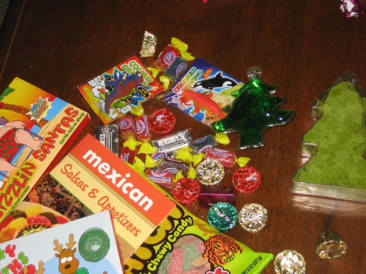 assorted candy items on wooden surface, including book and tree