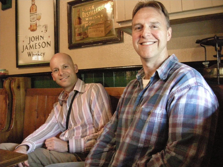 two men sitting next to each other in a restaurant