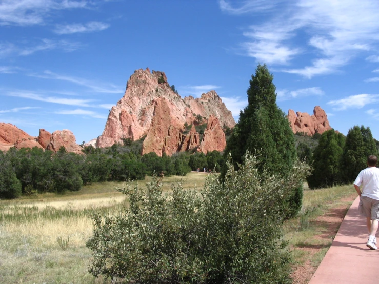 a man walking down a path on a sunny day