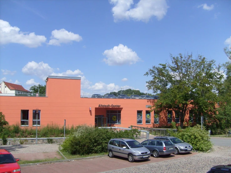 a few cars are parked near an orange building