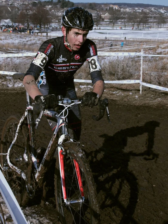 a guy standing by his bicycle during a bike race