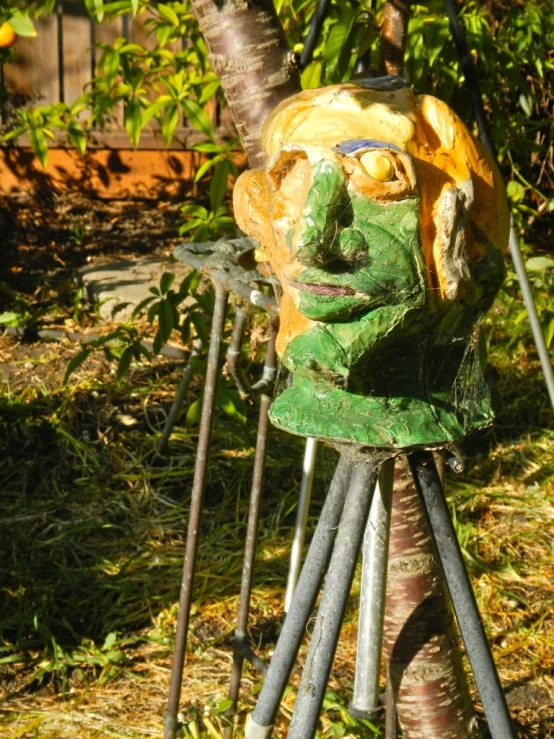 a green mask is on top of some metal forks