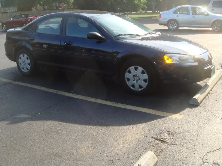 a black sedan parked in a parking lot