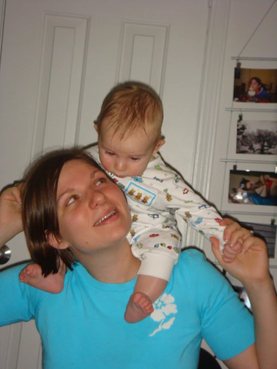 a woman holding her baby while he lifts up him