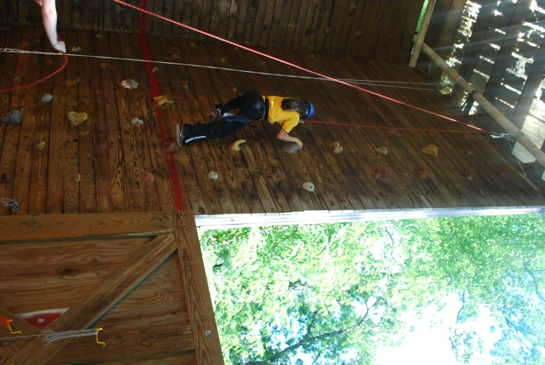 a boy climbing on a wall in a climbing gym