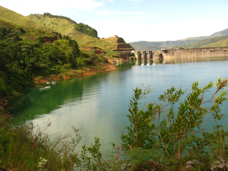 an overflowing river and bridge in front of a mountain