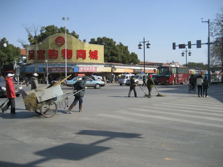 people hing soing in a big wheelbarrow on the street