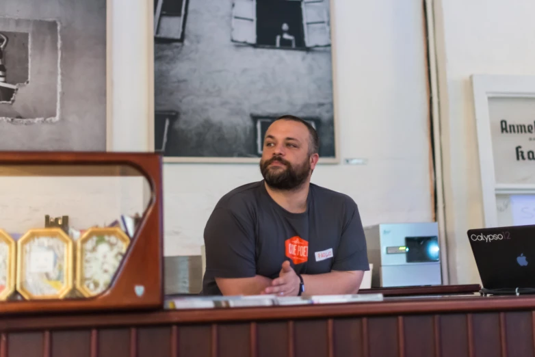 a man with a beard sitting behind a desk