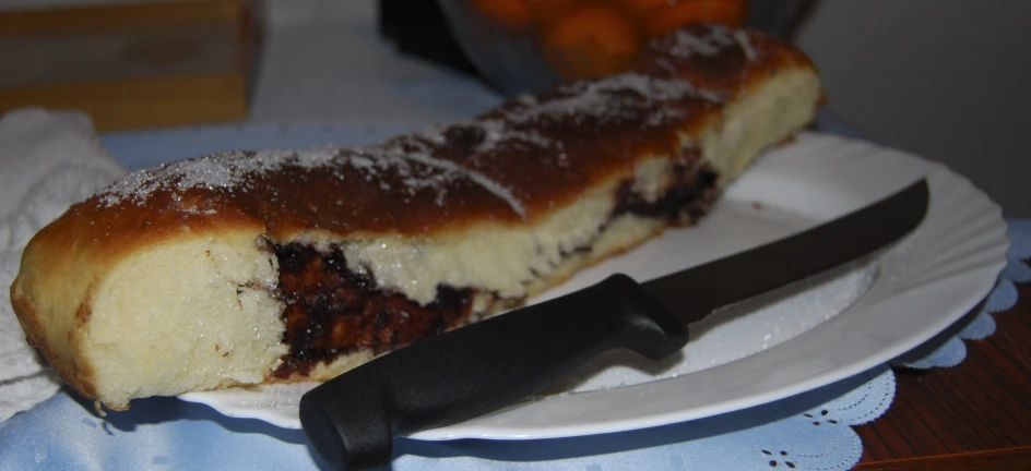 a cake on a white plate next to a knife