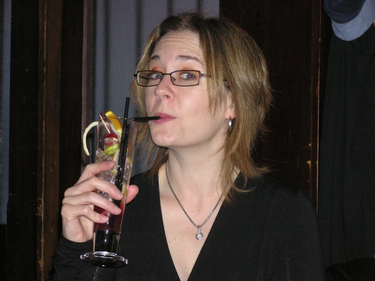 a young woman drinks wine out of an elegant glass