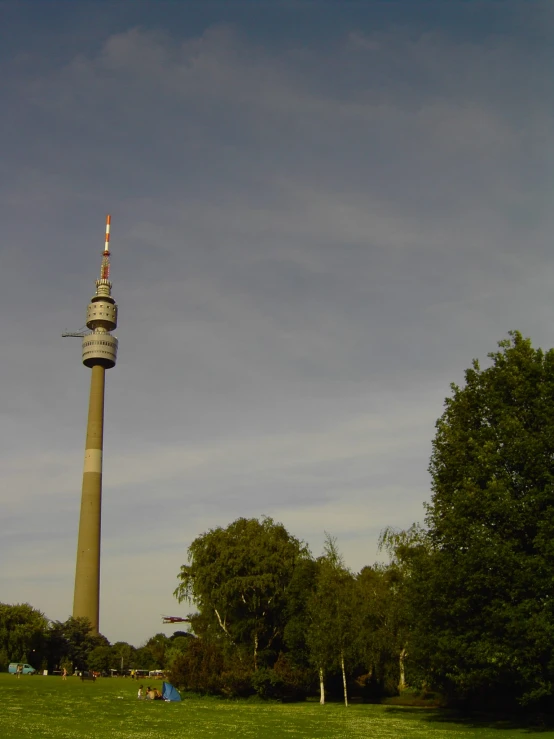 the radio tower is standing next to some trees