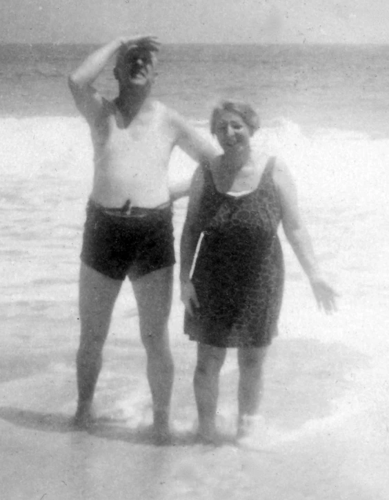 black and white po of two people in bathing suits on a beach