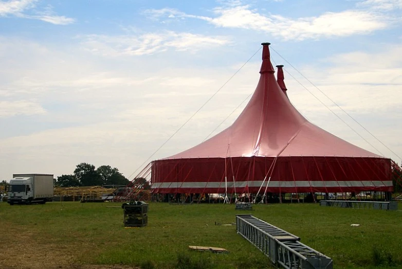 a big pink tent sitting in the middle of a field