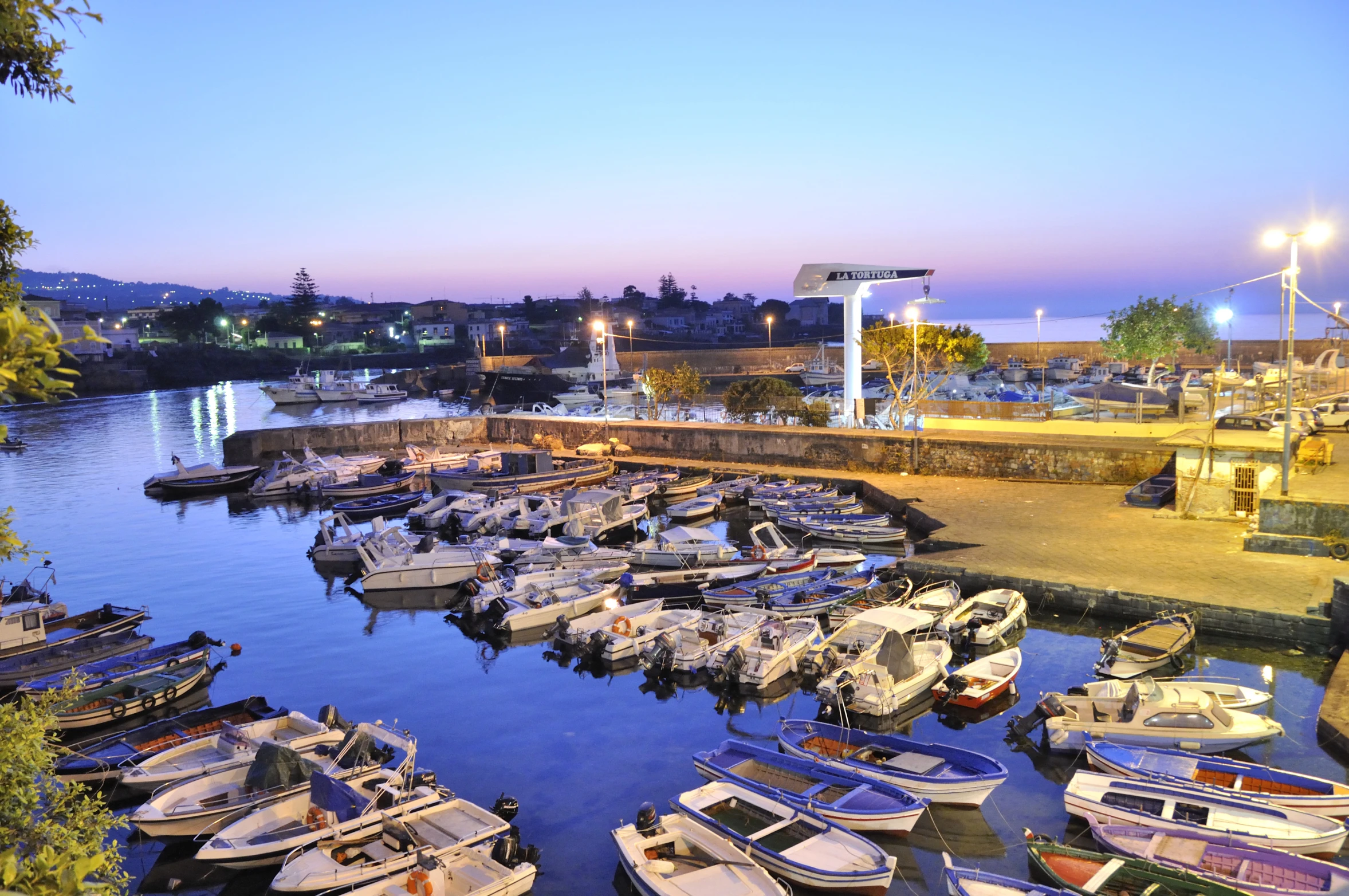 boats are docked on the water at dusk