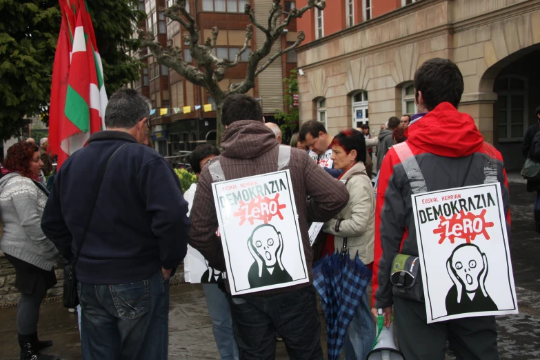 people walking with protest signs in front of buildings