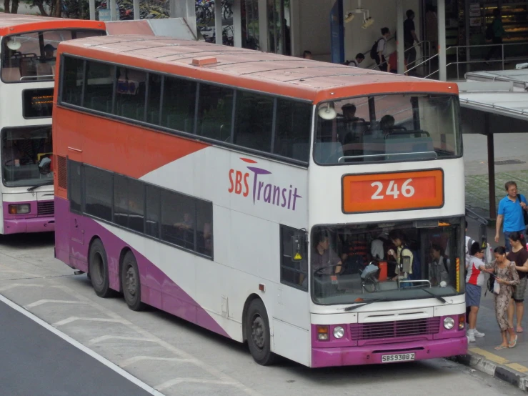 two double decker buses parked near a city sidewalk