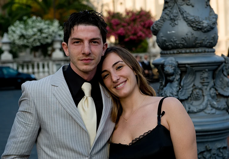 the couple is posing for a picture near the sculpture