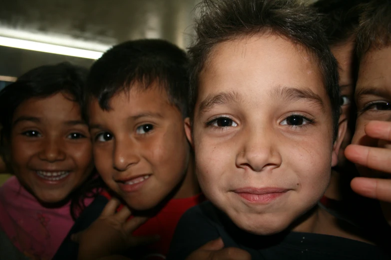 three children looking up and smiling, together