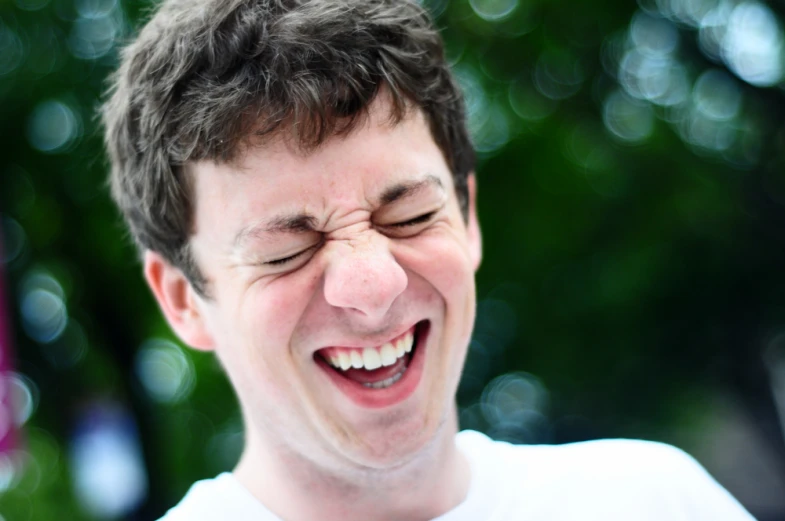 there is a man laughing while eating a donut