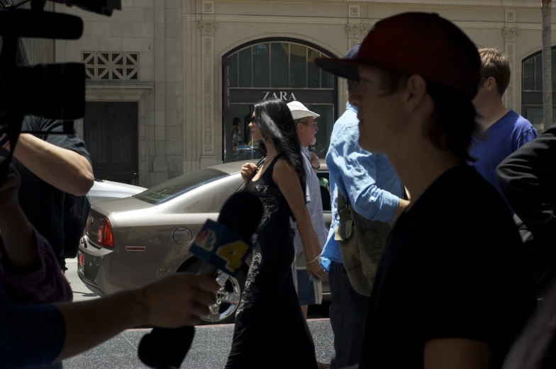 a group of people walking on the street near cars