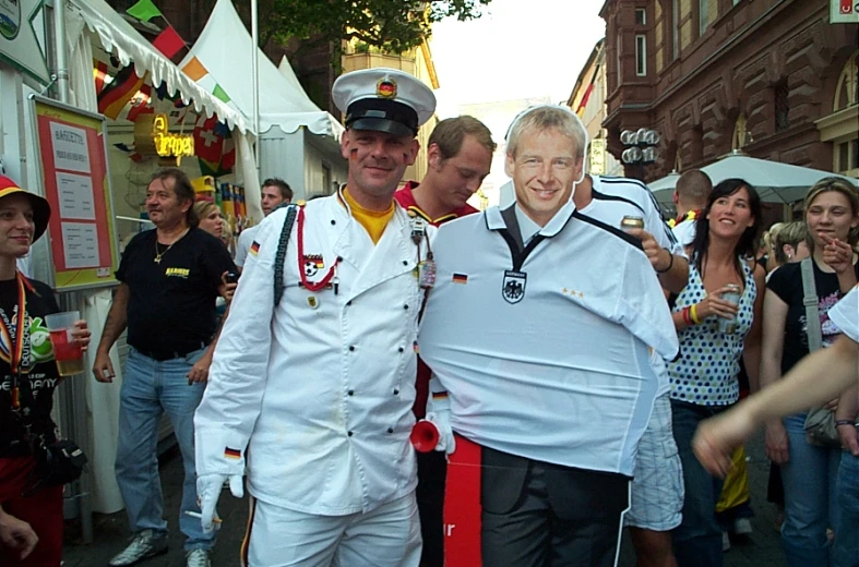 two gentlemen pose for a po in front of a crowd