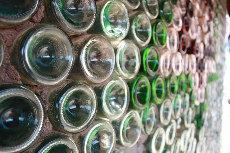 a wall with bottles hanging on it and a person looking at them