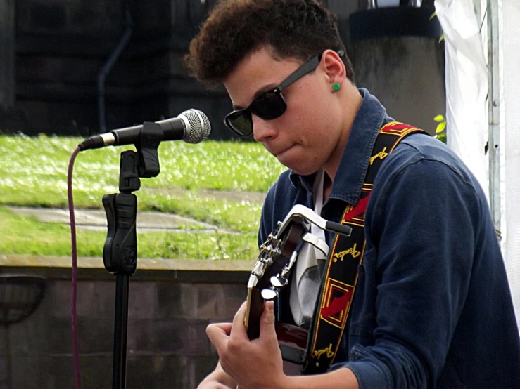 a young man is playing an acoustic guitar