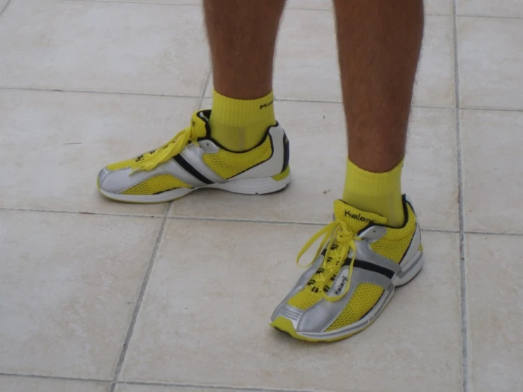 the man is wearing bright yellow socks and sneakers