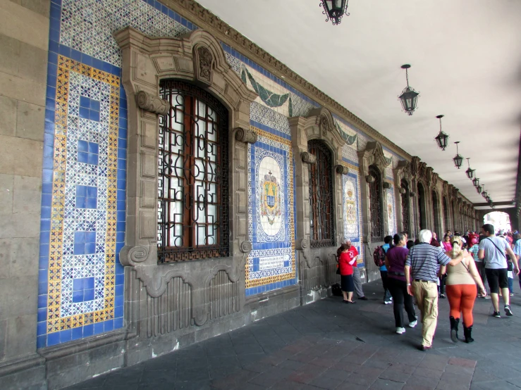 many people walk past painted windows on the wall