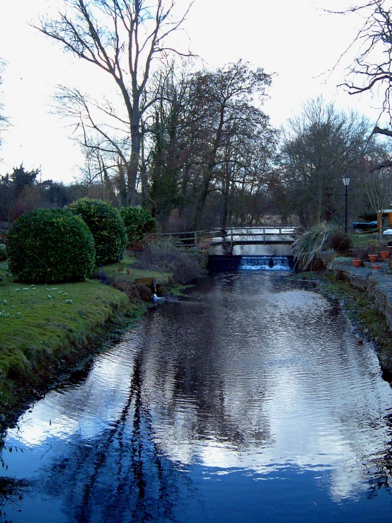 the small bridge over the water is reflected by the clouds