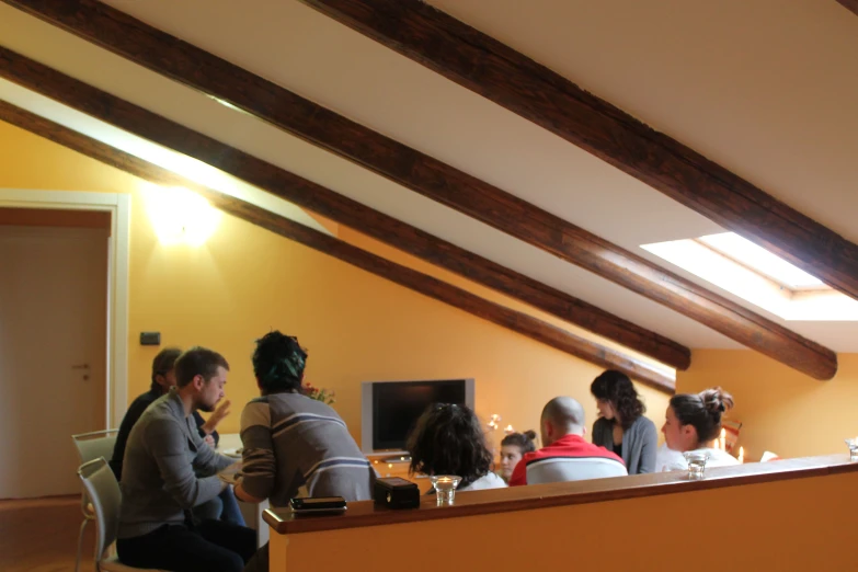 a group of people are seated and eating at the table