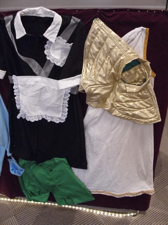 clothing sits on top of a table in front of an open red display case