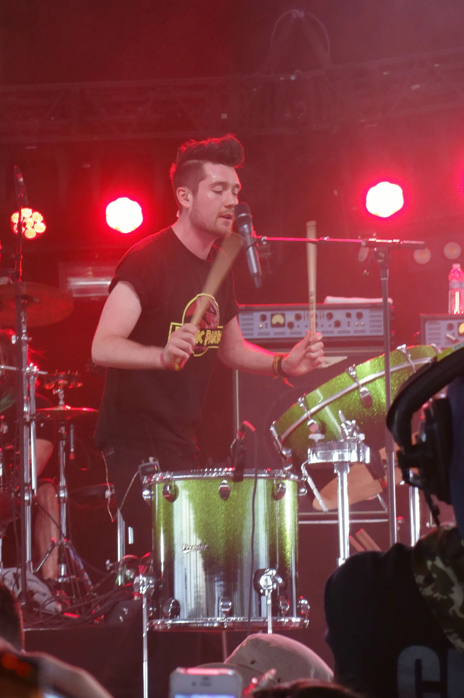 a man standing on stage holding a drums