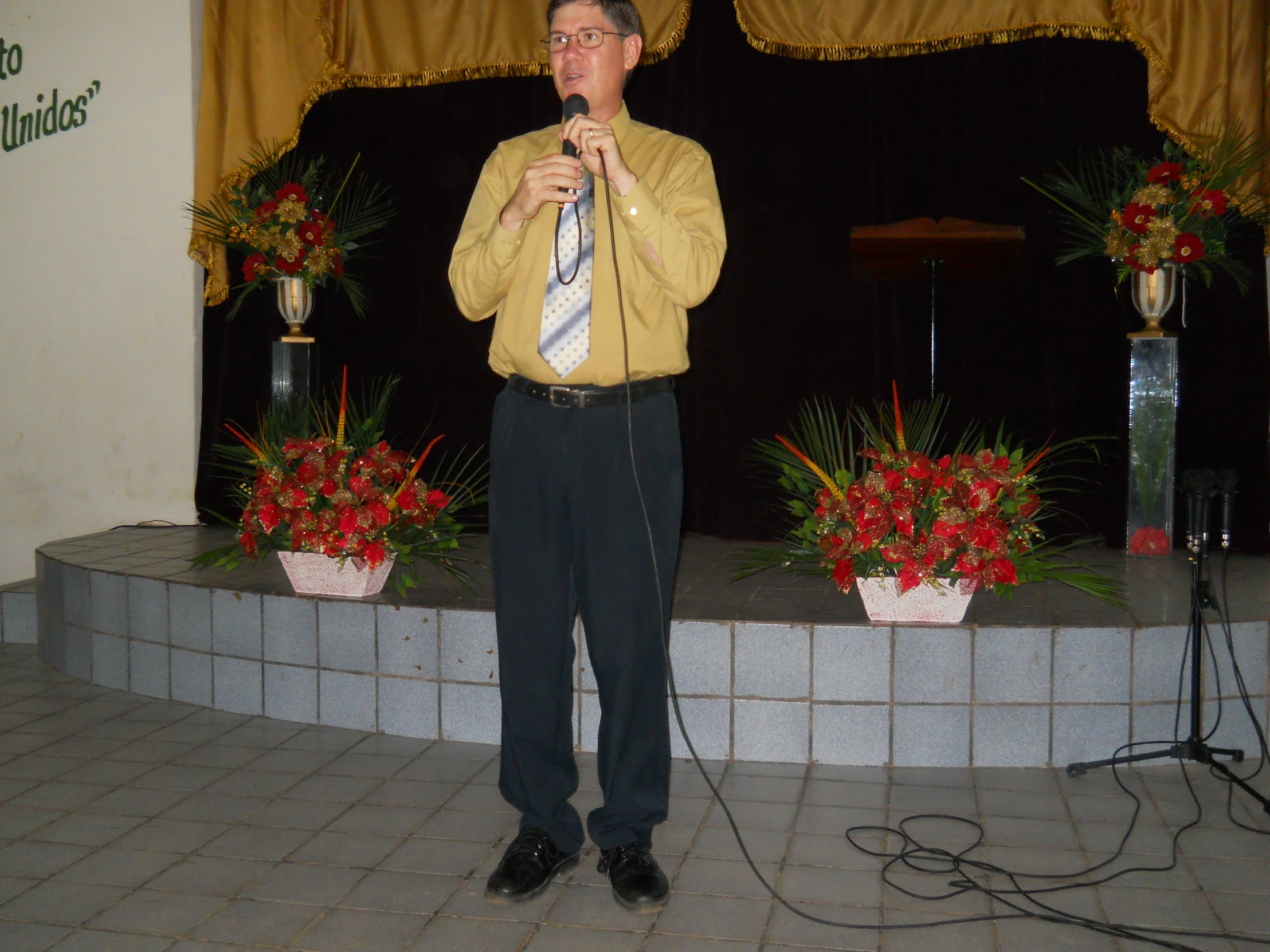 a man standing on a stage with his hands up to his chin