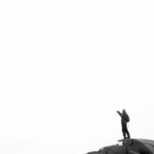 a man on top of a mountain holding a kite