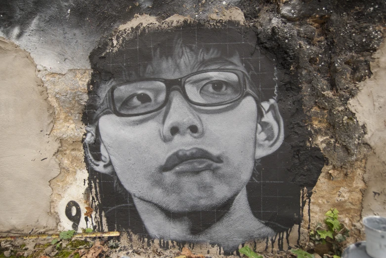 a graffiti painting on the wall of an old wall with a man wearing glasses