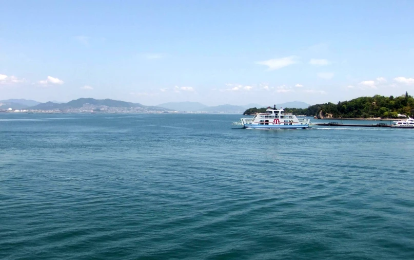 a boat floating in the blue water on a sunny day