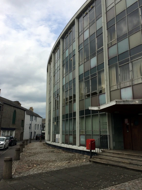 an old building with many windows next to some cars