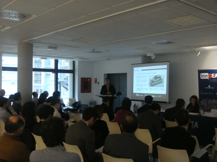 a group of people are sitting in chairs watching a seminar