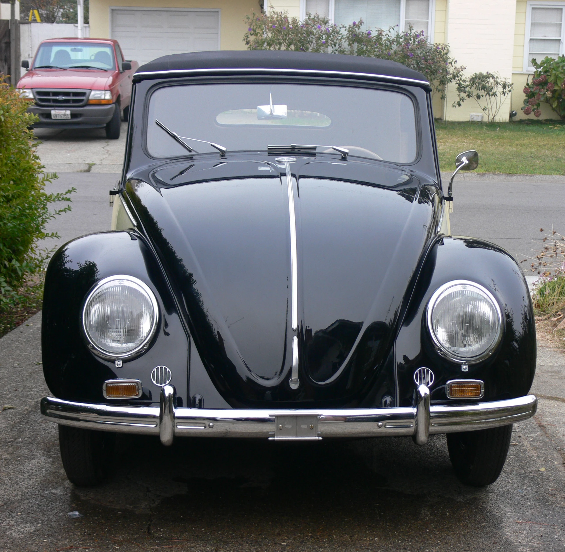 the front view of an old car in the driveway