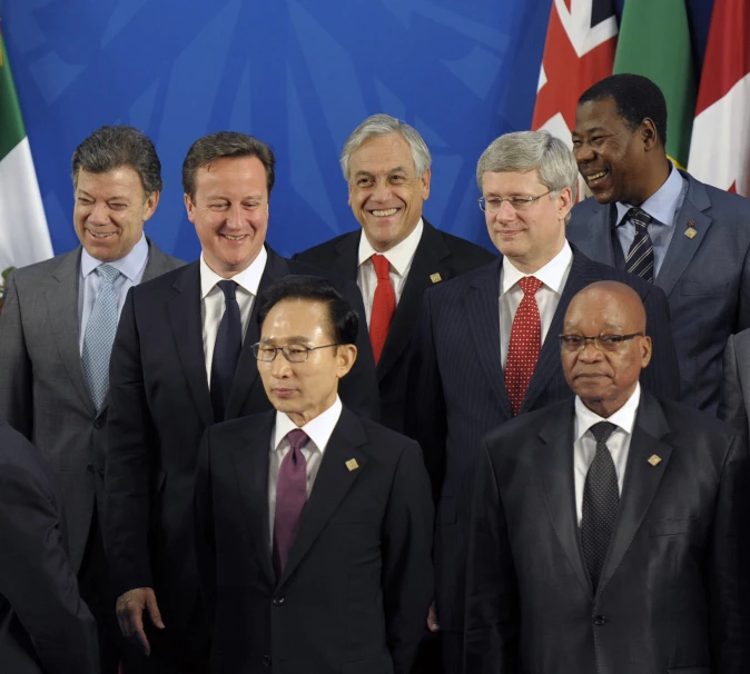 a group of people standing next to each other in front of flags