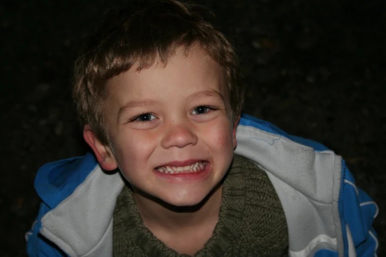 a boy in his jacket smiling for the camera