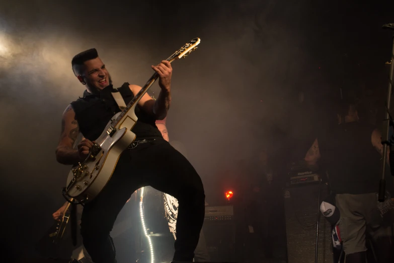 a man with an electric guitar on a stage