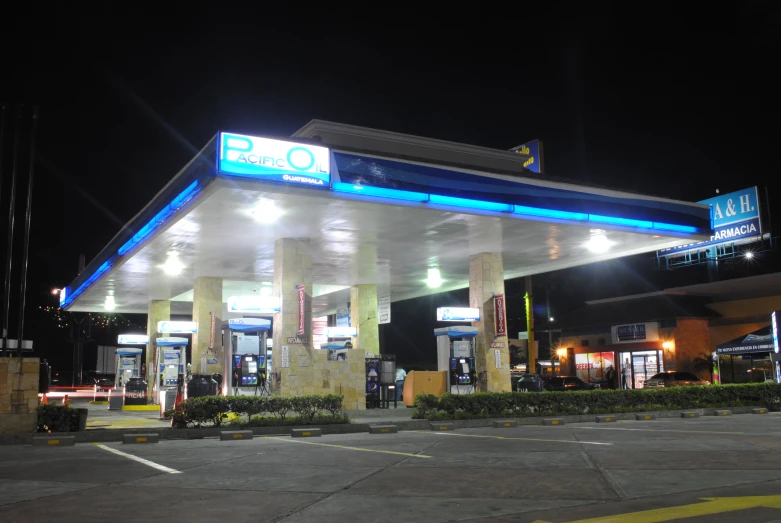 a gas station is shown at night with bright lights