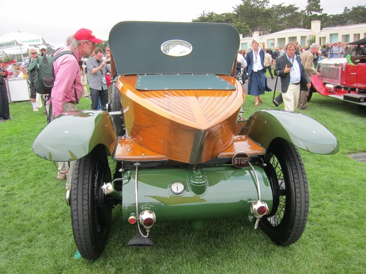 an old time looking green car on display