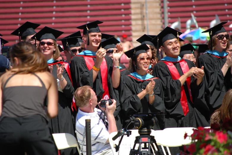 a group of people in graduation regalties at a ceremony