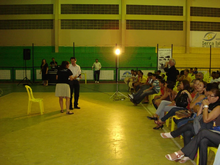 there is a man standing in front of people in a gymnasium