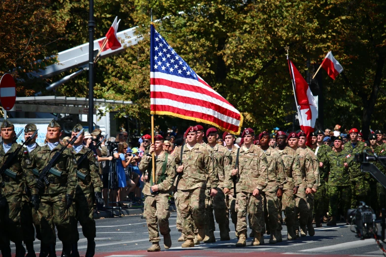 people are walking together holding the american flag